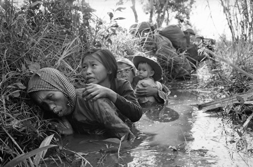 Foto van Vietnamese dorpelingen die schuilen in grachten omdat het nergens veilig is
